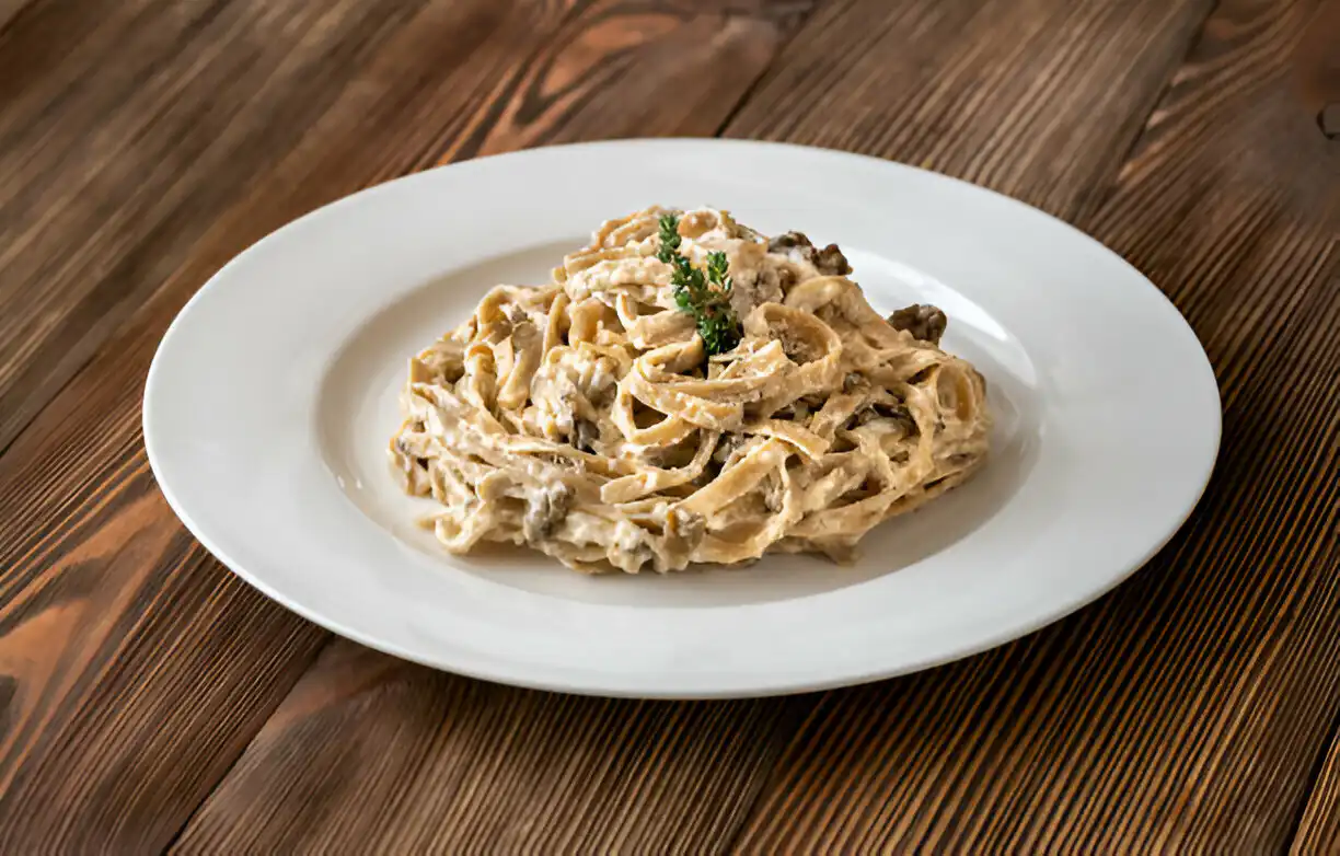 Creamy fettuccine pasta dish on a white plate