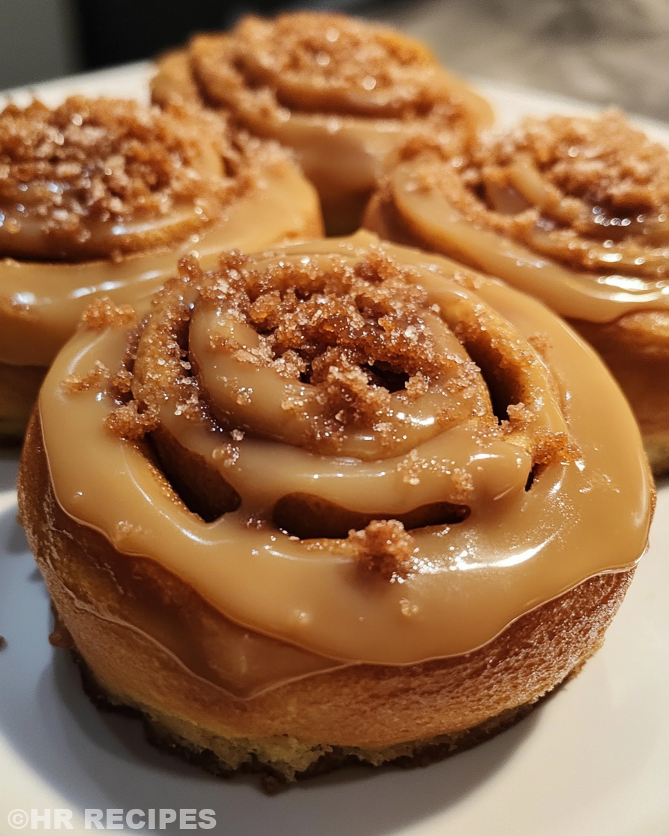 Golden baked Biscoff Cookie Butter Cinnamon Rolls on cooling rack with vegan cream cheese icing